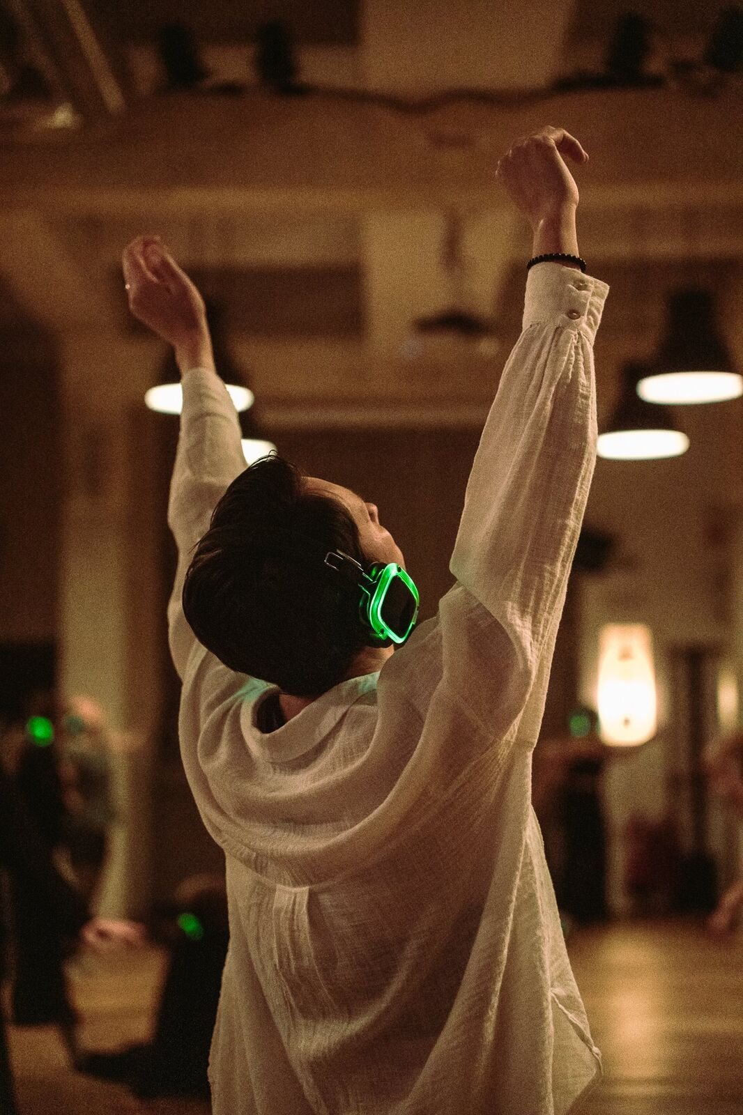 A dancer mid-motion, arms raised, in ecstatic movement